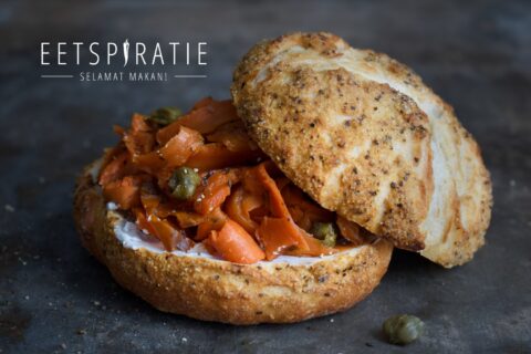 Een knapperig broodje met wortelzalm, roomkaas en kappertjes