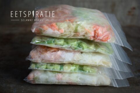 Opgestapelde zakjes met ingevroren groenten