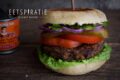 Zwarte bonenburger op een broodje met sla, tomaat, augurk, rode ui en chipotle pepers in adobosaus