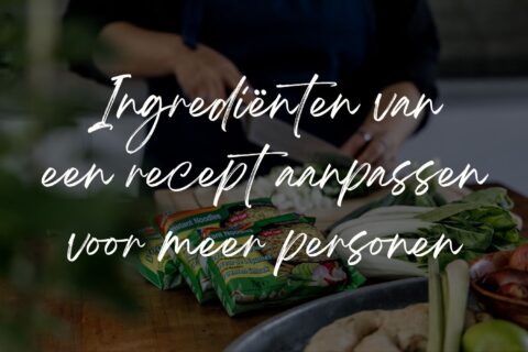 Het snijden van groenten en daar liggen andere ingrediënten omheen. Tekst op de foto: Ingrediënten van een recept aanpassen voor meer personen