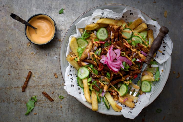 Een bord friet met tempeh topping